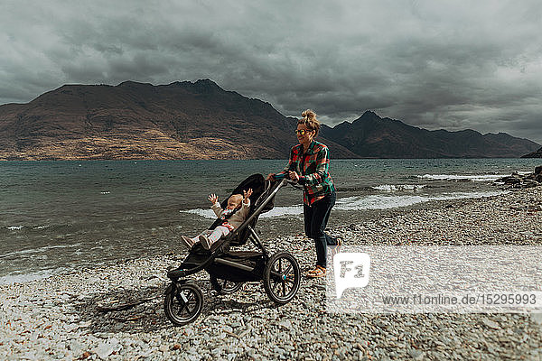 Mother with baby in pram walking on beach  Queenstown  Canterbury  New Zealand