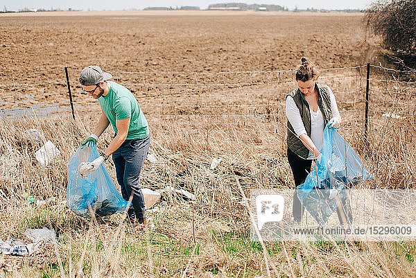 Couple picking up rubbish by field  Georgetown  Canada