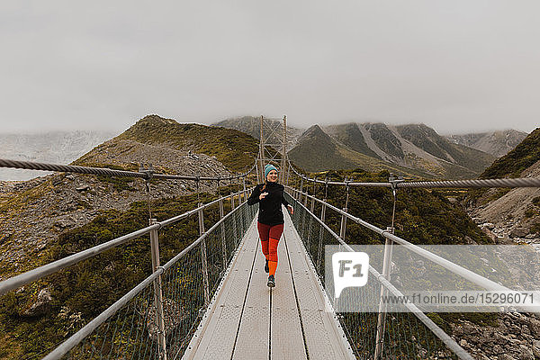 Hiker crossing suspension bridge  Wanaka  Taranaki  New Zealand