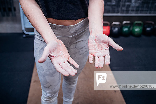 Young woman showing calluses on palms in gym