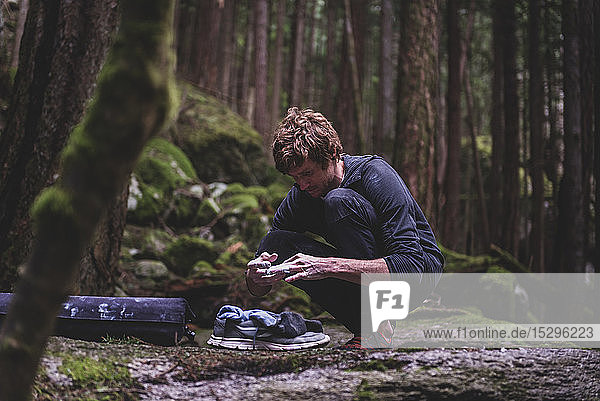 Kletterer klebt Finger vor dem Bouldern im Wald ab  Squamish  Kanada