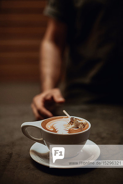 Barista an der Café-Theke mit einer Tasse Mokka mit geröstetem Marshmallow  abgeschnittener flacher Fokus