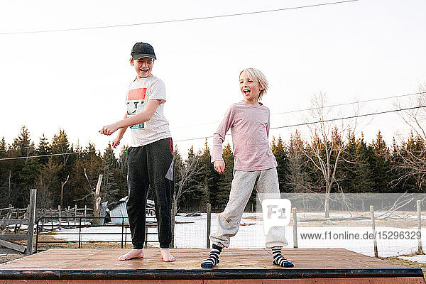 Boy and sister dancing on top of rural concrete slab