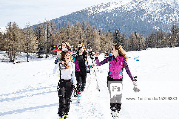 Fünf jugendliche Skifahrerinnen wandern in verschneiter Landschaft  Tirol  Steiermark  Österreich