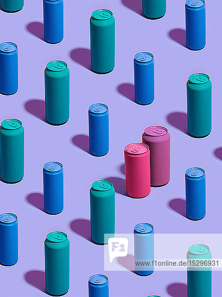 Stilleben aus türkisfarbenen und blauen Getränkedosen in diagonalen Reihen  wobei sich rosa und violette Getränkedosen auf violettem Hintergrund von der Menge abheben