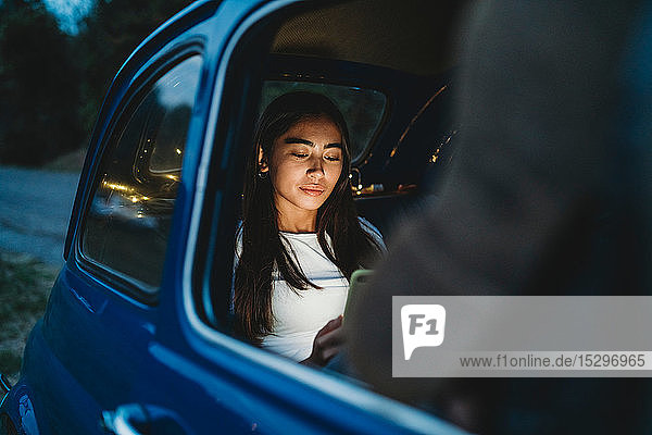 Woman using smartphone inside car