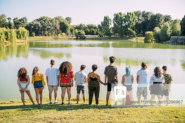 Eine Gruppe von Freunden genießt die Aussicht auf den See im Park