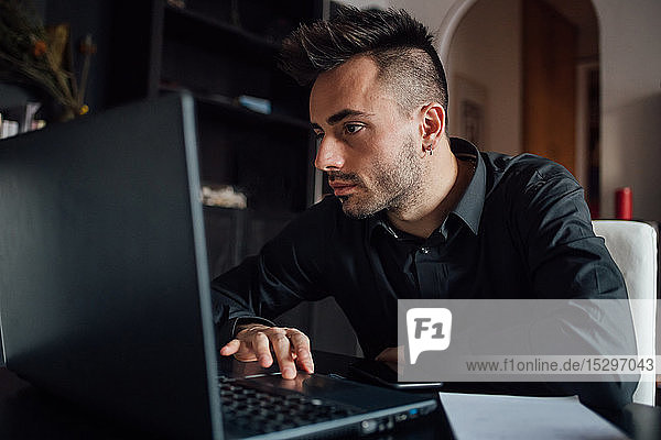 Mann benutzt Laptop im Heimbüro