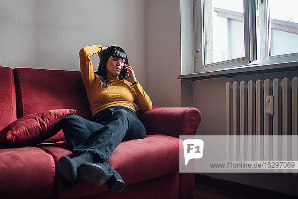 Woman talking on smartphone on sofa