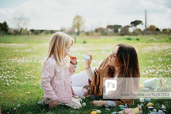 Mother and daughter relaxing in wildflower field after easter egg hunt  Arezzo  Tuscany  Italy