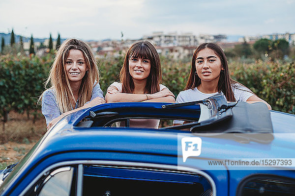 Freunde posieren neben dem Auto auf dem Land  Florenz  Toskana  Italien