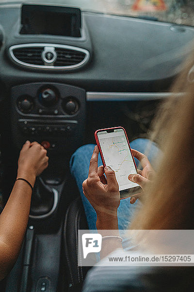 Freunde nutzen Smartphone im Auto