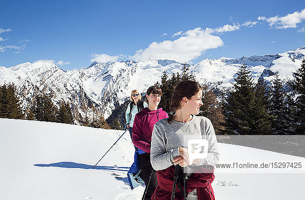 Teenager mit Mutter und Schwestern beim Schneeschuhwandern in schneebedeckten Bergen  Steiermark  Tirol  Österreich