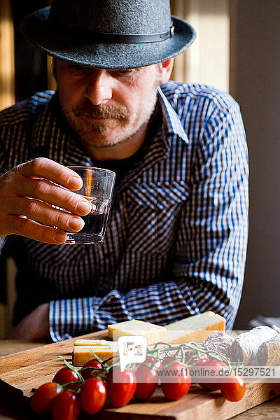Mann trinkt Wein und isst mediterranes Essen im Café