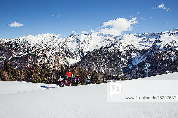Reifes Paar und Töchter beim Schneeschuhwandern in schneebedeckter Berglandschaft  Steiermark  Tirol  Österreich