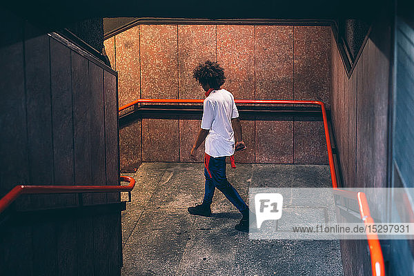 Junger Mann geht die Treppe hinunter