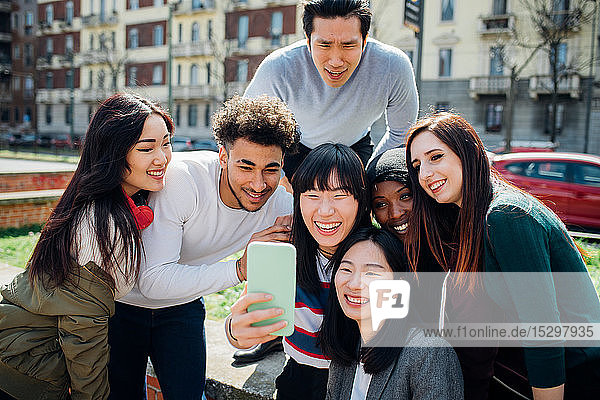 Junge männliche und weibliche erwachsene Freunde nehmen Smartphone-Selfie in der Nähe der Stadtstraße