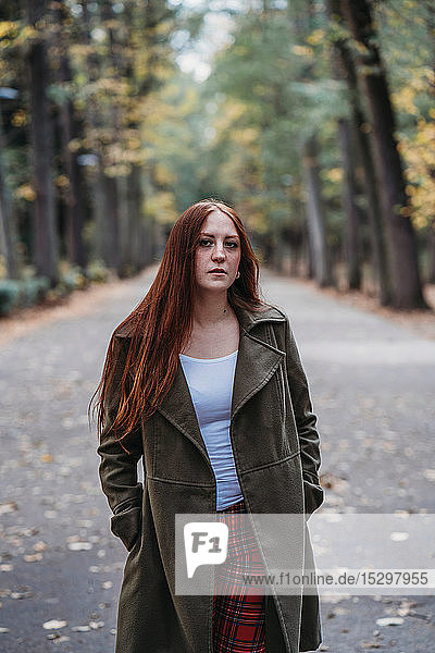 Young woman with long red hair in autumn park  portrait