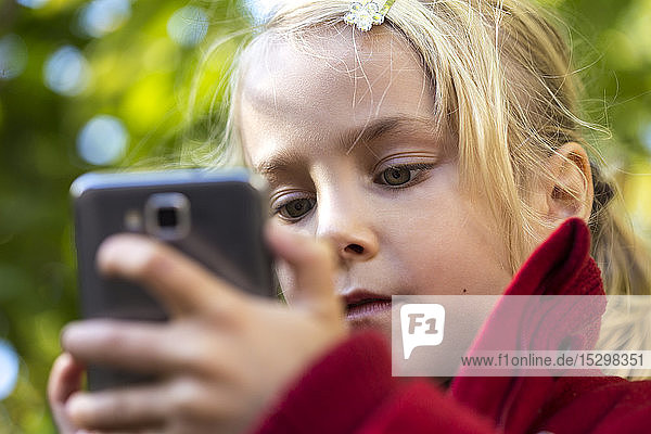 Porträt eines kleinen Mädchens mit Smartphone