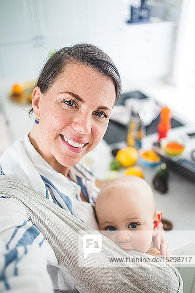 Hochwinkelporträt einer lächelnden Mutter und Tochter in der heimischen Küche