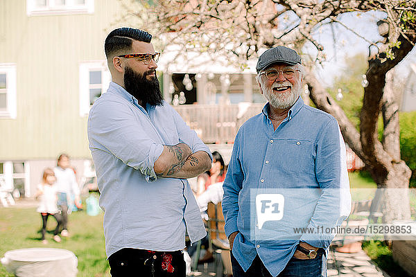 Lächelnder Vater und Sohn unterhalten sich  während sie zusammen im Hinterhof stehen