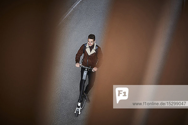 High angle view of teenage boy riding electric push scooter on street
