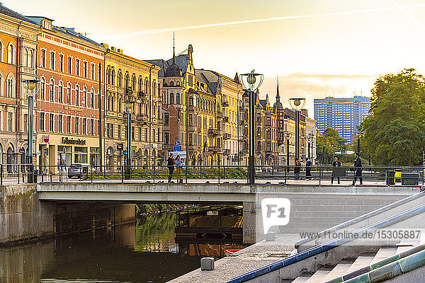 Houses by Sodra Forstadskanalen in city during sunset
