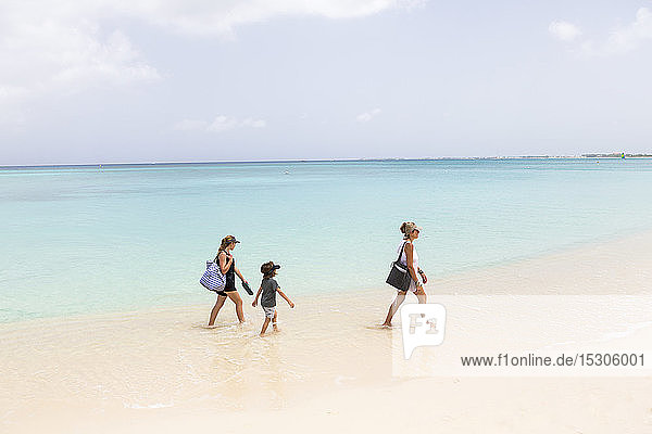 Mutter und ihre Kinder gehen am Strand spazieren