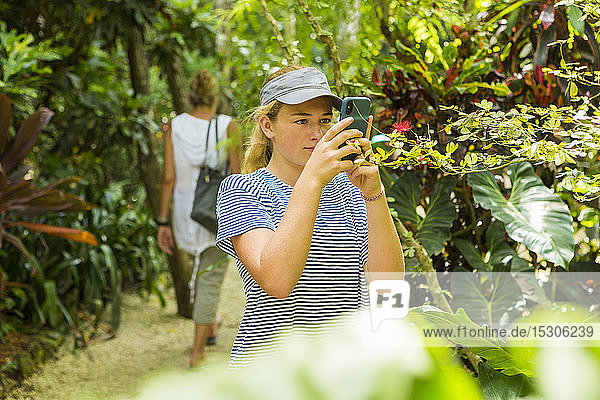 Ein junges Mädchen fotografiert mit einem Smartphone auf einem Naturlehrpfad