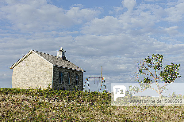 Tallgrass Prairie Preserve  ein historisches Schulhausgebäude und eine Pappel im Frühling.