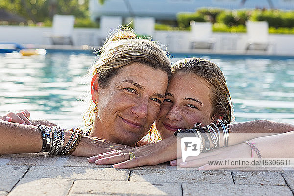 Mutter und ihre 13-jährige Tochter lächelnd im Pool