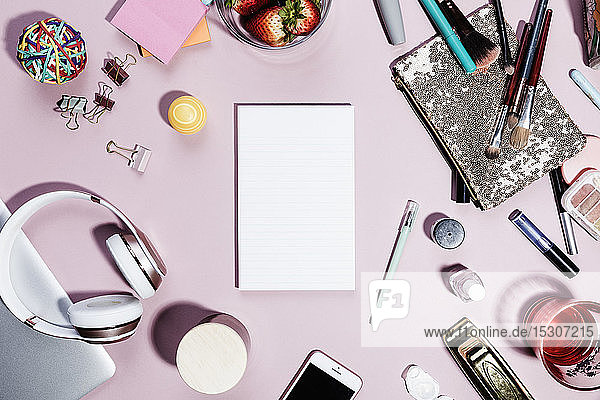 Ansicht Formular über leeren Notizblock umgeben von persönlichen Gegenständen auf rosa Hintergrund