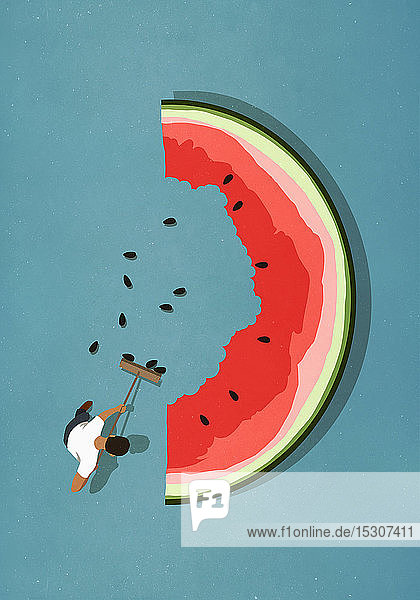 Mann mit Besen  der Kerne von einer großen Wassermelonenscheibe fegt
