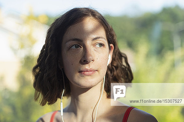 Thoughtful woman listening to music with headphones