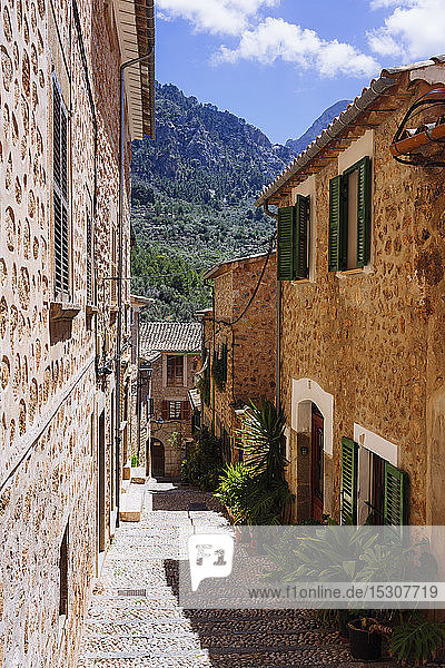 Sonnige Straße mit Kopfsteinpflaster und Häusern  Fornalutx  Mallorca  Balearische Inseln  Spanien