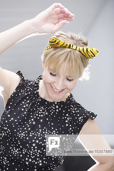 Playful woman in cat costume ears dancing