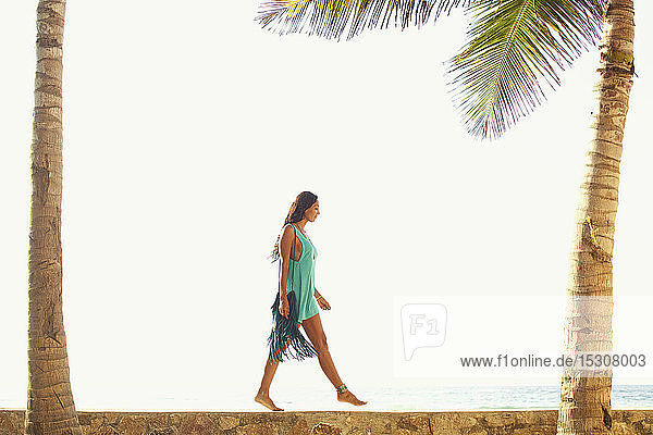 Frau spaziert entlang des sonnigen Meeresrandes