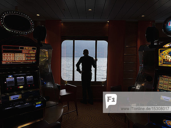 Silhouette Mann mit Blick auf das Meer von Kreuzfahrtschiff Casino Fenster
