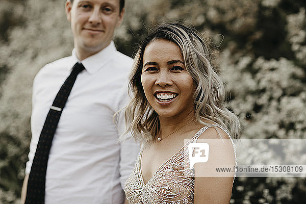 Portrait of happy bride and groom outdoors