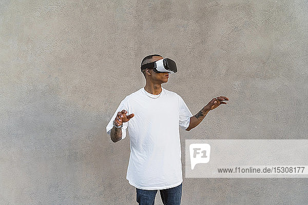 Tätowierter junger Mann mit Virtual-Reality-Brille