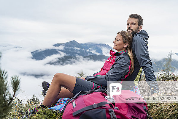 Affectionate young couple on a hiking trip in the mountains having a break  Herzogstand  Bavaria  Germany