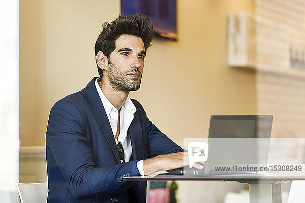 Businessman using laptop in an urban cafe