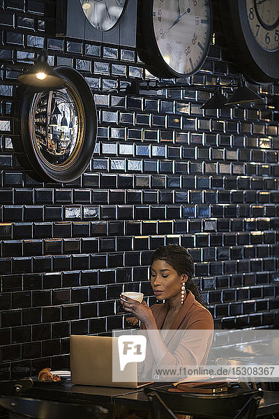 Schicke Geschäftsfrau mit Laptop am Tisch in einem Cafe
