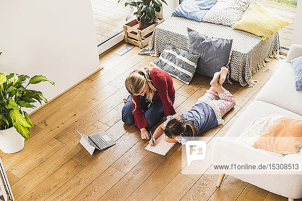 Mother helping daughter with homework at home