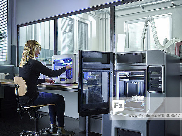 Weibliche Technikerin prüft 3D-Drucker mit Turbinenrad beim Drucken