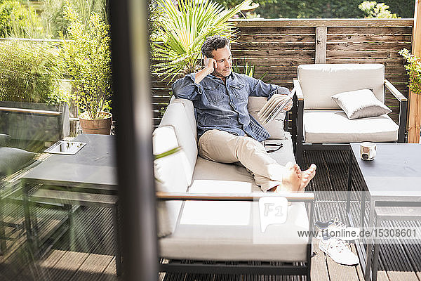 Confident man relaxing on the terrace reading book