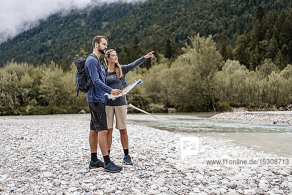 Young couple on a hiking trip with map looking around  Vorderriss  Bavaria  Germany