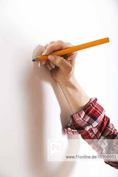 Markierung einer Frau mit Bleistift an einer Wand