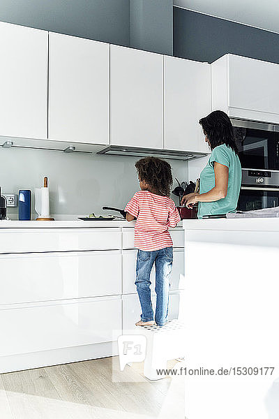 Mother and daughter cooking in kitchen together