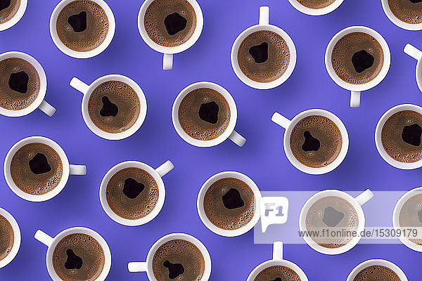 Direkt darüber Ansicht von frischem Kaffee in Tassen über violettem Hintergrund